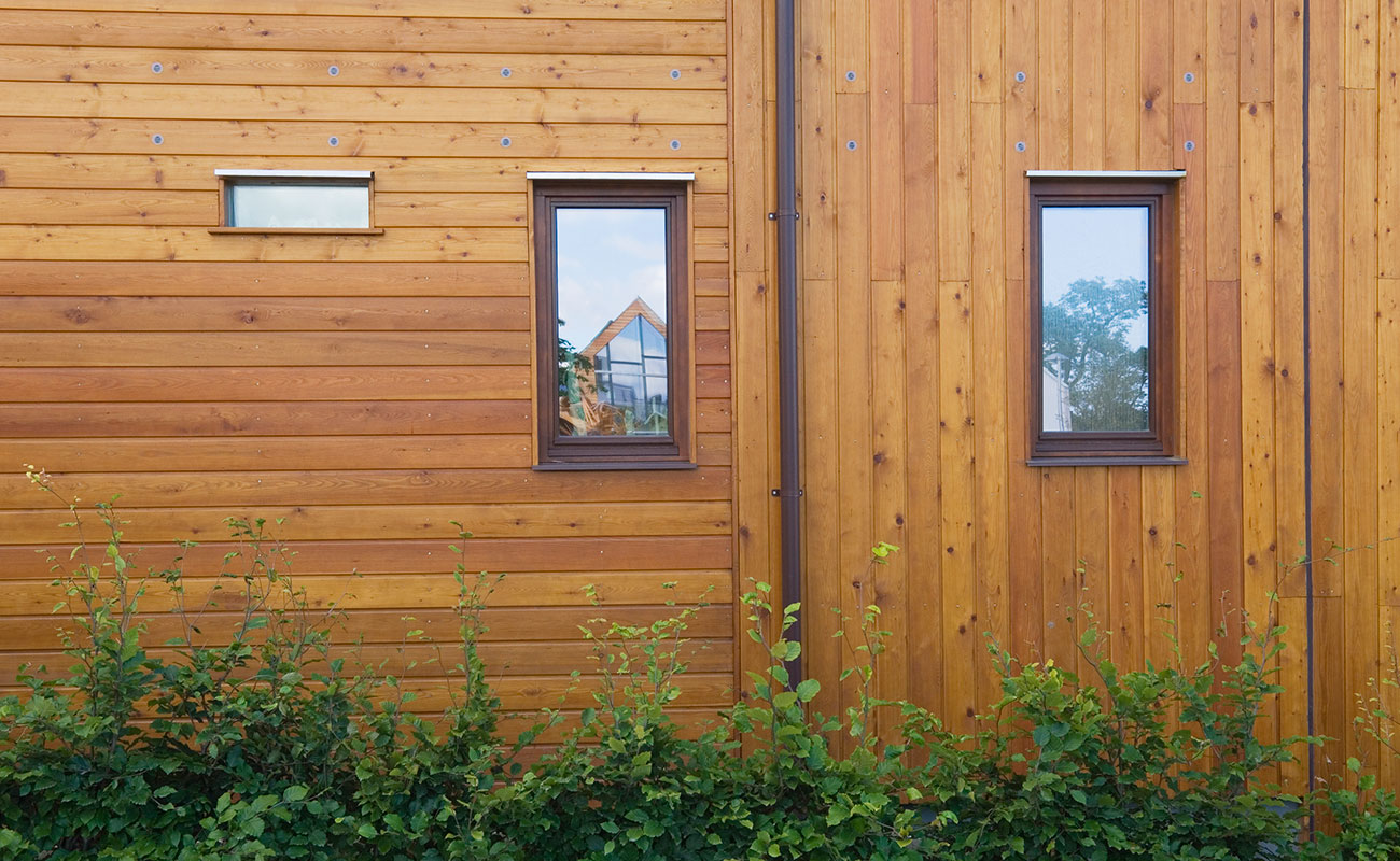 High end recladded home with horizontal and vertical natural wood panels