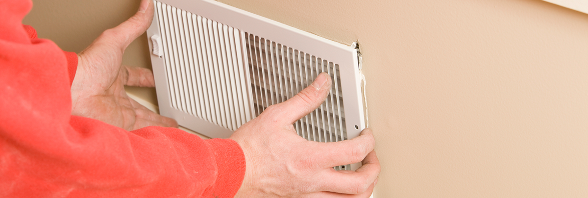 Person installing ventilation system into wall.