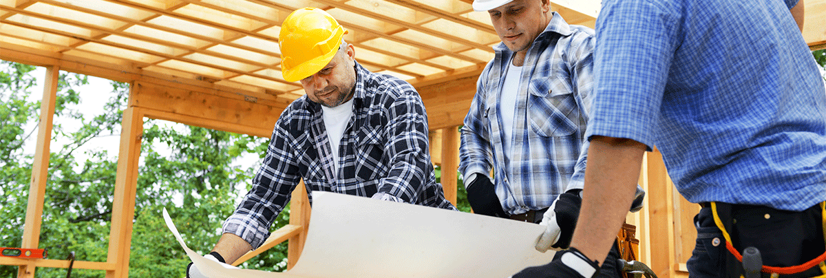 Construction workers looking at renovation house plans
