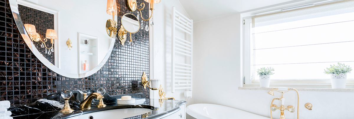 Bathroom with black tiled feature wall and round mirror