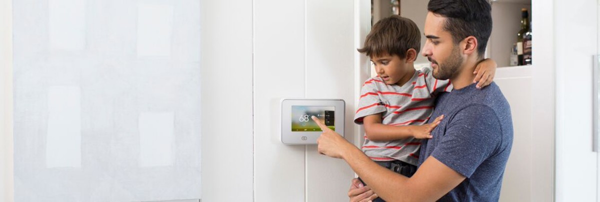 White Vivent GoControl controller on white wall with father and son using the device