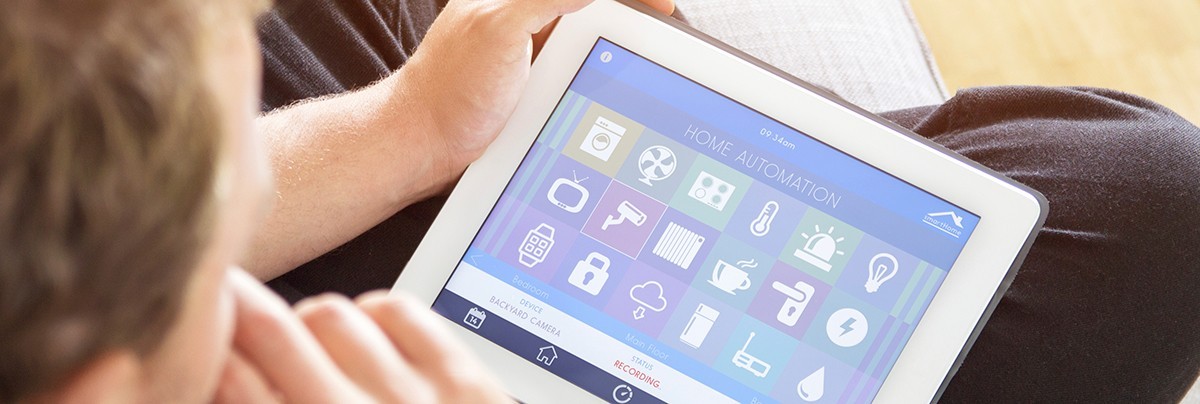 Young man using a wireless tablet to check his home security systems.