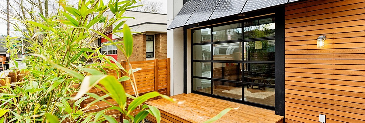 Backyard entrance with a floor to ceiling window entrance with solar panels at the top
