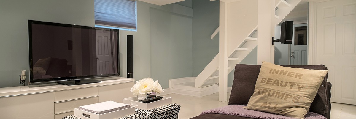 Stairway leading to a basement living room with TV