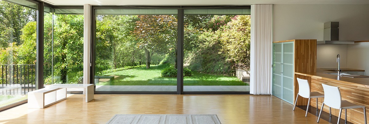 Living room with wooden floors and french sliding doors giving way to a beautiful lawn