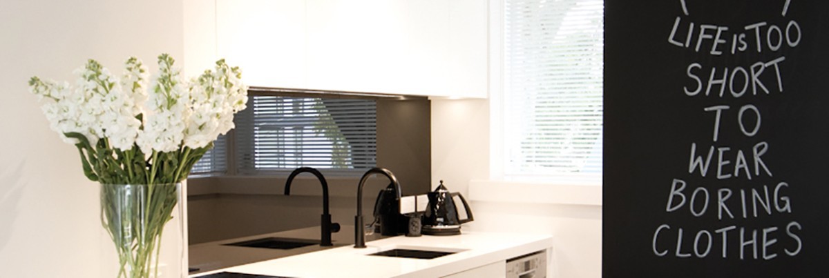 White modern kitchen with design chalkboard saying ''life is too short to wear boring clothes''