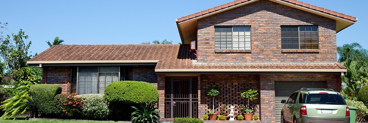 A brick house with a car park next to it