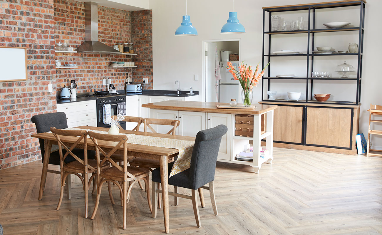 An open-plan kitchen with brick wall