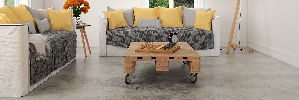 A living room with concrete floor and yellow cushions
