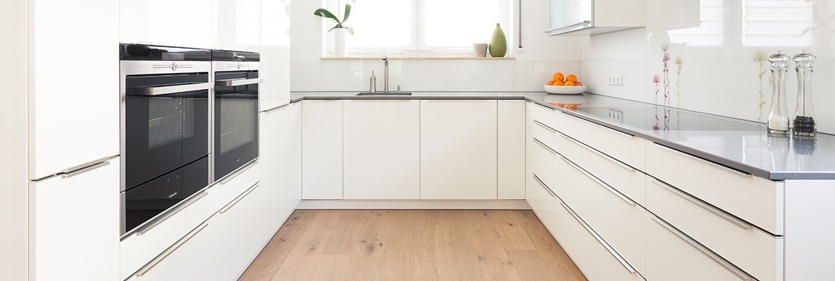 A renovate kitchen with white cupboard and wooden floor
