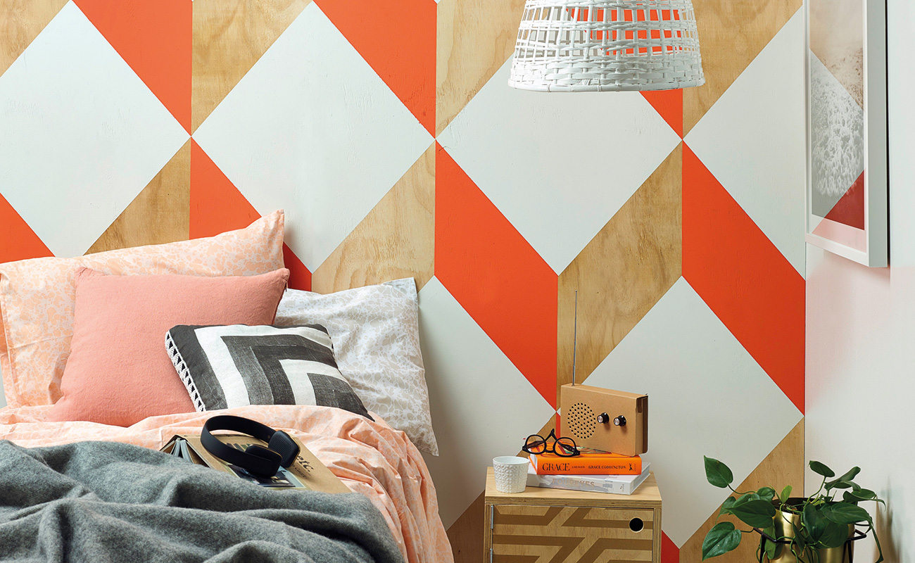 A bedroom with orange pattern wall decoration