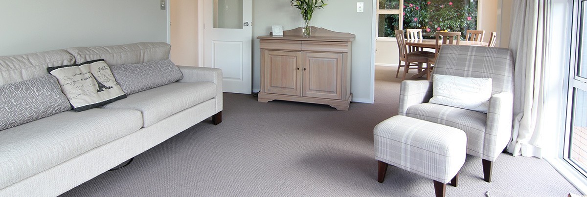 A living room with white couch and side table