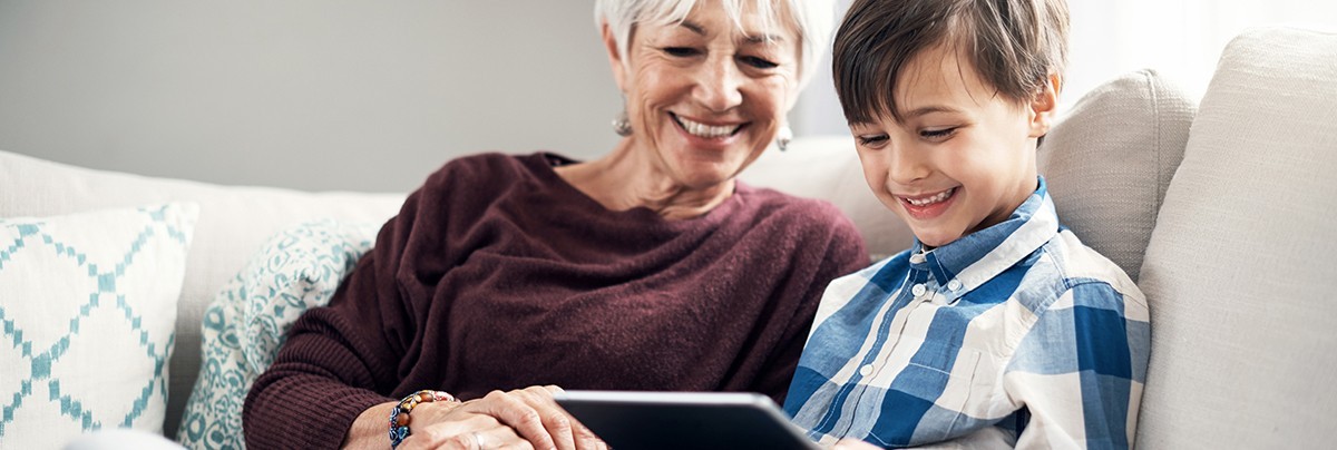 Grandma and grandson are looking at a  tablet