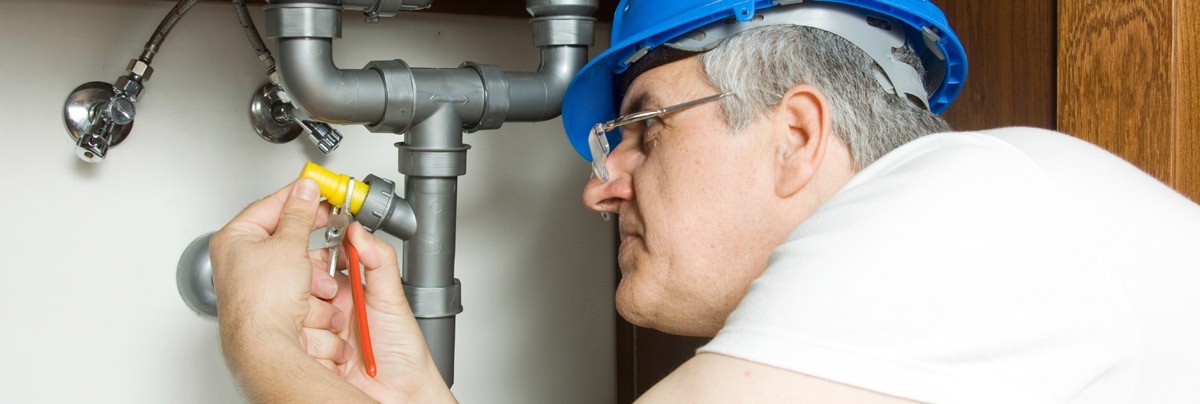 man fixes burst pipe