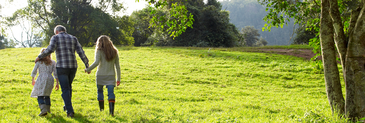 ECO FRIENDLY FAMILY WALKS THROUGH A FIELD