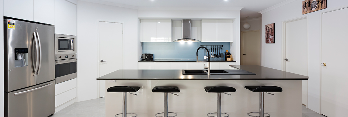 Kitchen bench with stools, blue splashback is visible in the background