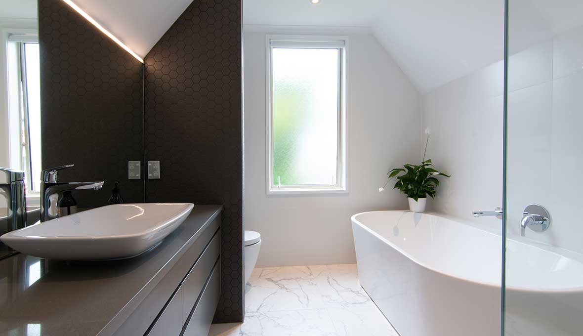 minimalistic bathroom with sloped ceiling and dark feature wall