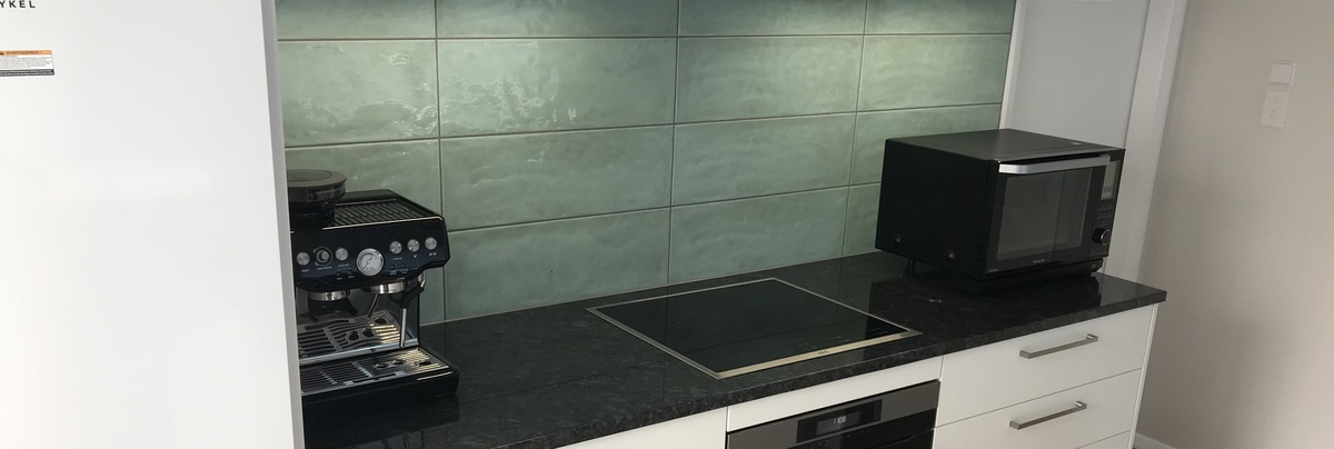 Renovated kitchen with green splashback
