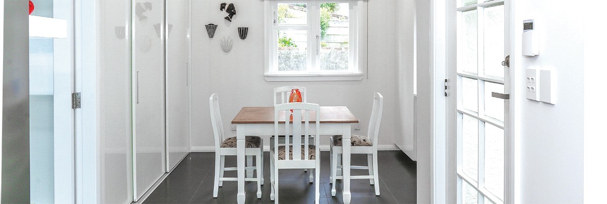 The new kitchen features white walls and furniture to contrast with the black tiling.