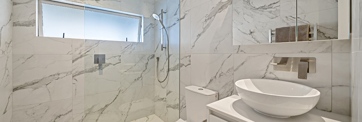 Marble tiling, organic shapes, and improved functionality bring these bathrooms to life for effortless luxury.