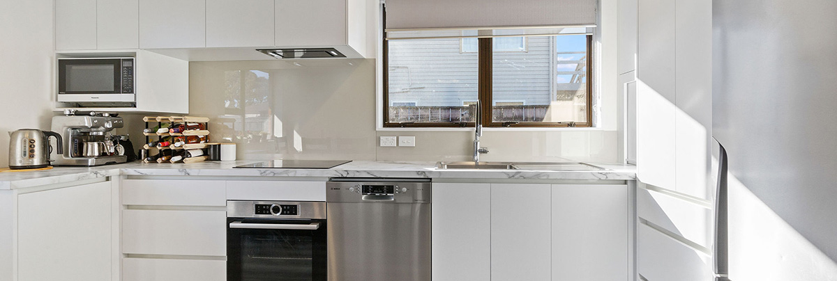 You'll find both function and finesse in this kitchen packed with ingenious storage solutions and a sleek, white colour scheme.