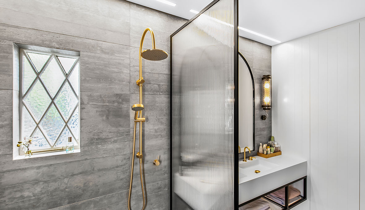 Gray tile bathroom with gold fixtures