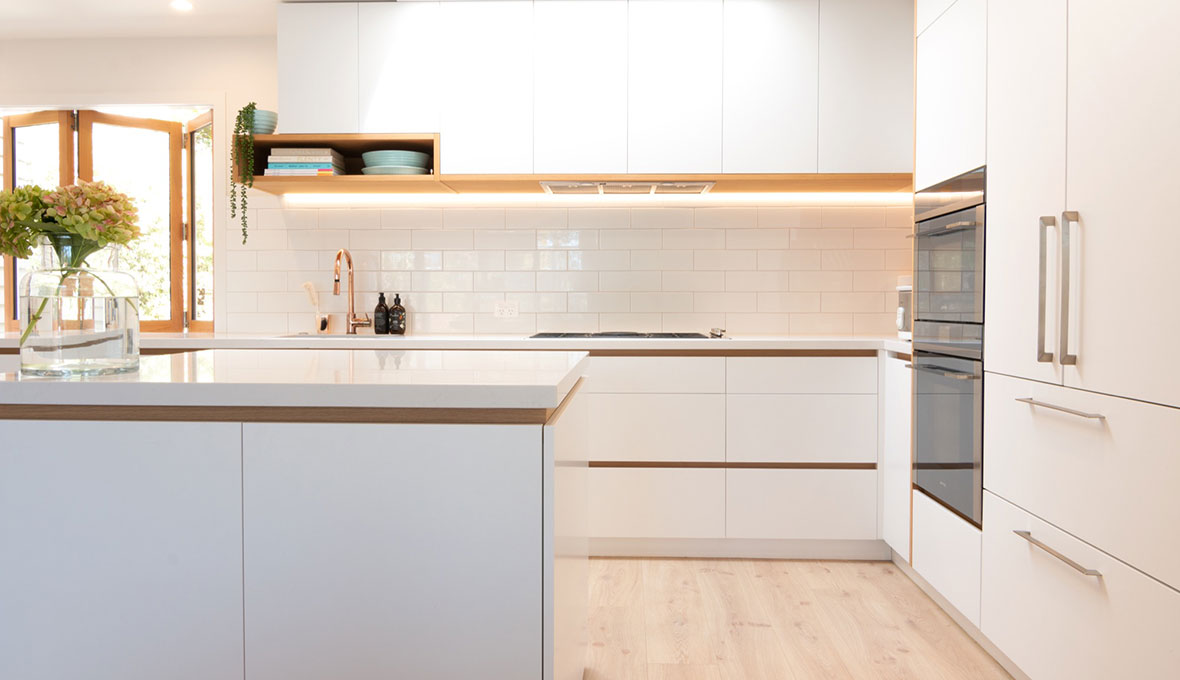 modern white kitchen with wood features and LED light under cabinets