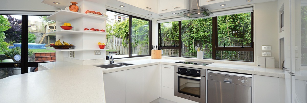 Revamped kitchen with creamy stone flecked Cheltenham bench surface and open-faced corner wall shelves