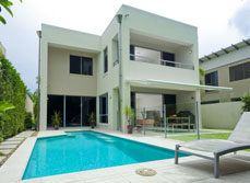 Outdoor, in ground, backyard swimming pool with glass panel fencing
