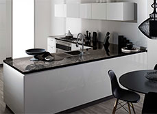 Black marble with brown specs kitchen countertop, in sharp contrast with white white cabinetry