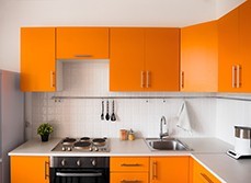 Home kitchen renovation with orange cabinet, basic appliances.
