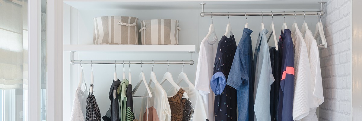 Two sideway levels of hangers in a modern but simple walk-in wardrobe