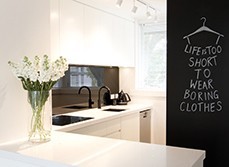 White modern kitchen with design chalkboard saying ''life is too short to wear boring clothes''