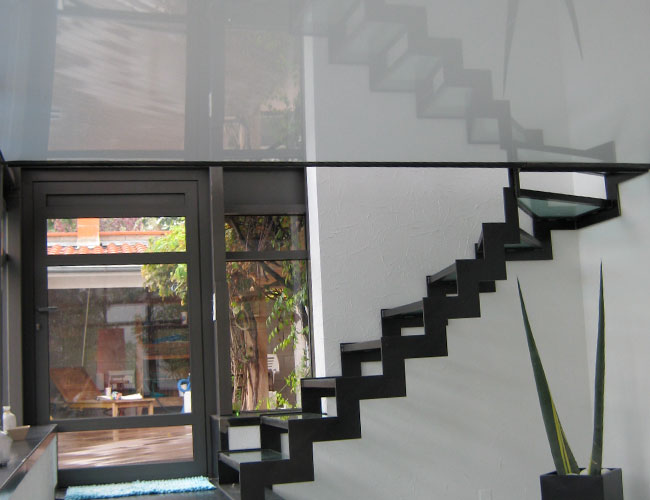 Two storey home with metal staircase using PVC as a ceiling for first storey and as flooring for second storey 