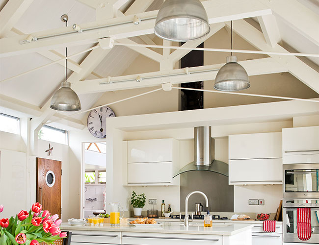 Exposed ceiling, showing white beams across peaked roof in white motif, industrial kitchen