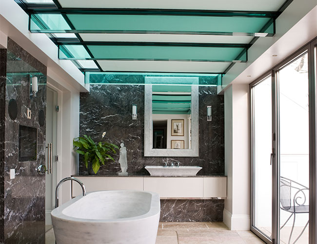 Glass panelled cutouts hanging vertically from ceiling in Grecian inspired bathroom