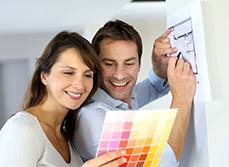 Woman using colour cards and tablet to research future colour scheme