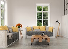 A living room with concrete floor and yellow cushions