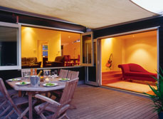 Windows and doors opening up from living room to outdoor patio.