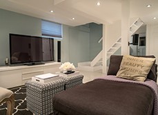 Stairway leading to a basement living room with TV