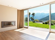 Living room with floor to ceiling sliding doors and view of garden