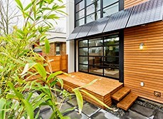 Backyard entrance with a floor to ceiling window entrance with solar panels at the top