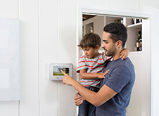 White Vivent GoControl controller on white wall with father and son using the device