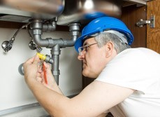 man fixes burst pipe