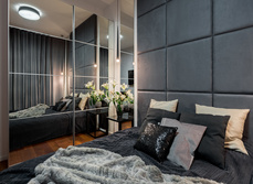 A bedroom with mirrored walls to make it look larger
