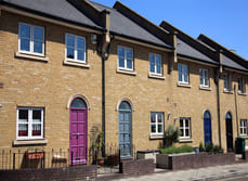 A row of modern terraced houses with coloured front doors