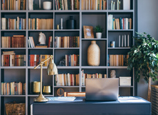 A study with large book case, decorated in dark shades