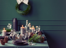 A dinner table set for a Christmas meal with decorations