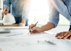 Two workers reviewing project plans.