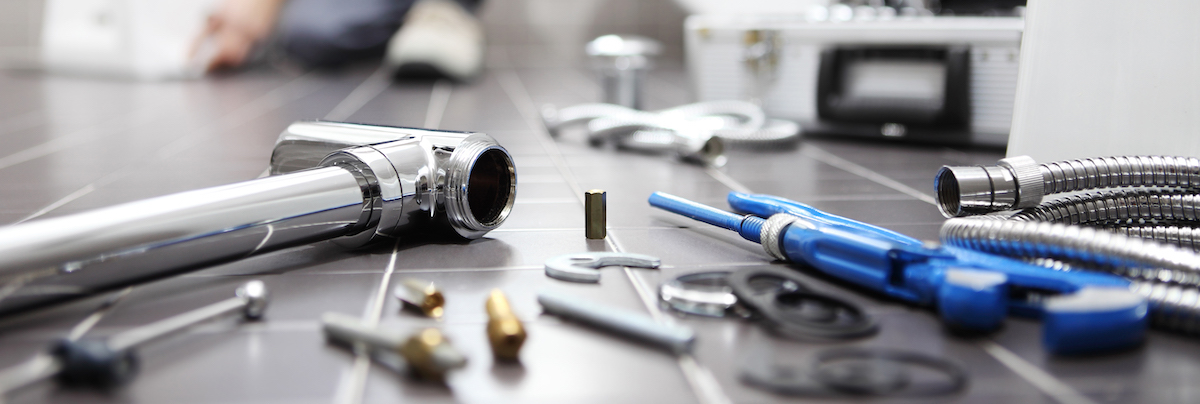 Plumbing tools on the floor of a bathroom